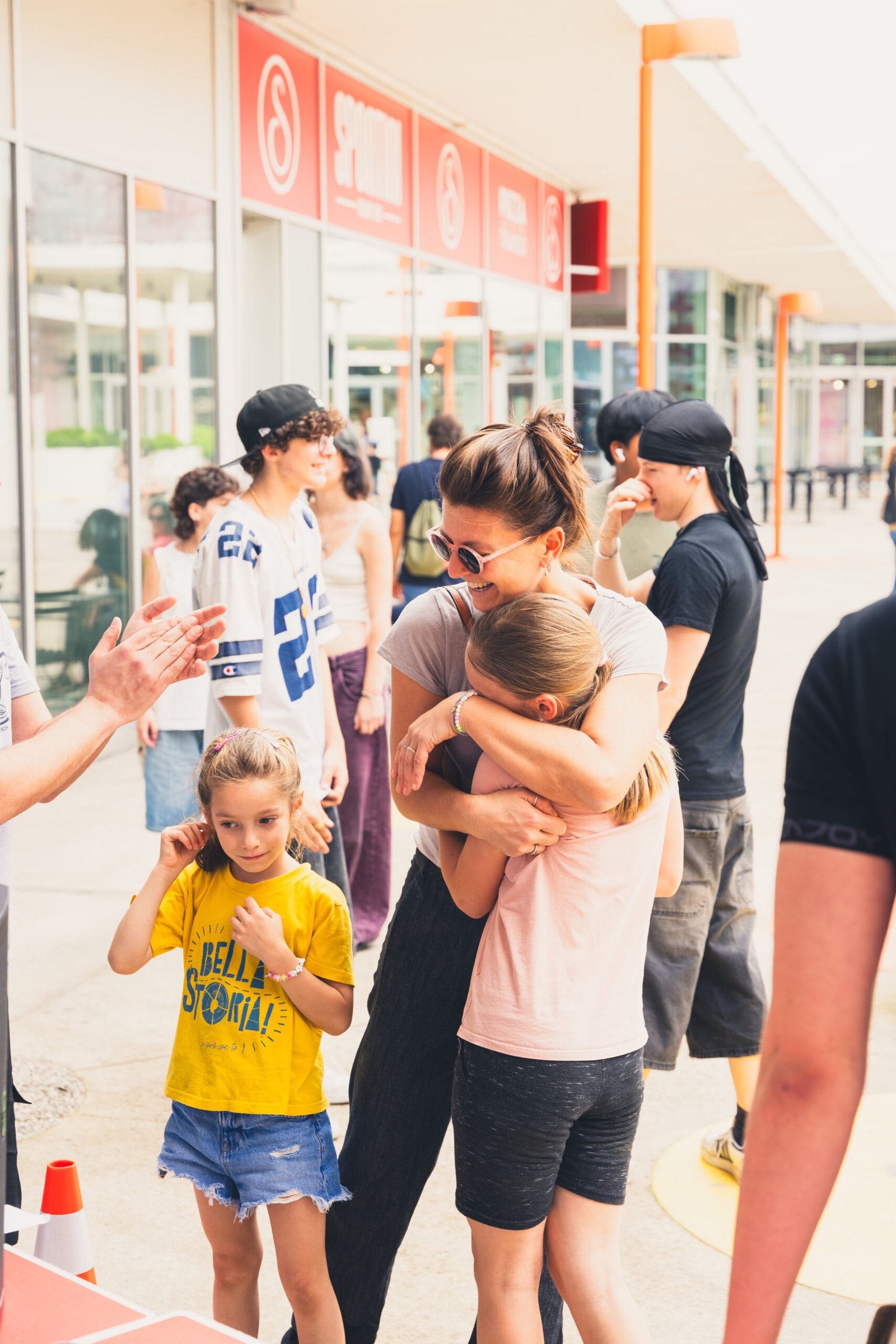 DSC04368 mamma e figlia che si abbracciano e intorno persone che si divertono e stanno insieme. questo e' il potere dello sport di strada, inclusione per donne e bambini